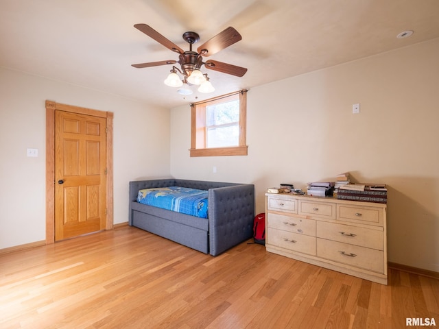bedroom with light wood finished floors, baseboards, and a ceiling fan