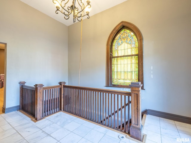 empty room with baseboards and an inviting chandelier