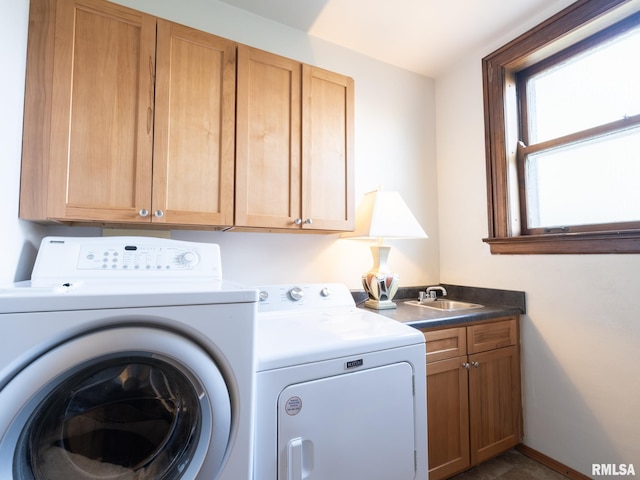 laundry area with baseboards, washer and dryer, cabinet space, and a sink