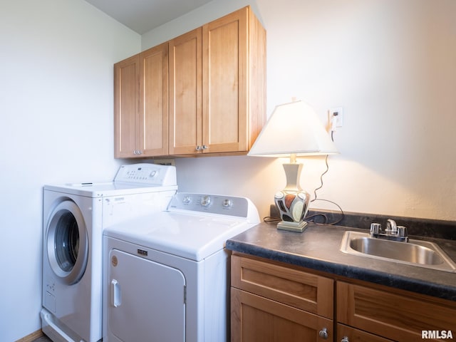 laundry room featuring a sink, washer and clothes dryer, and cabinet space