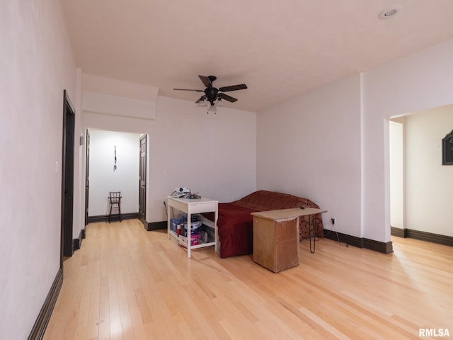 interior space featuring baseboards, light wood-type flooring, and a ceiling fan