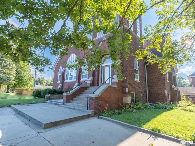 view of front of property featuring brick siding and a front yard