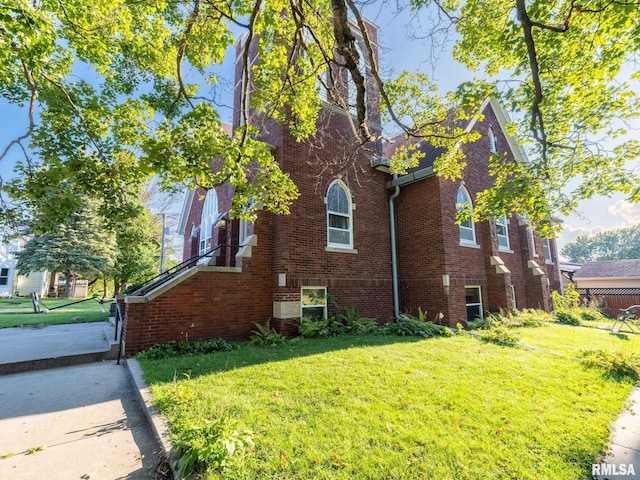 view of side of property with a lawn and brick siding