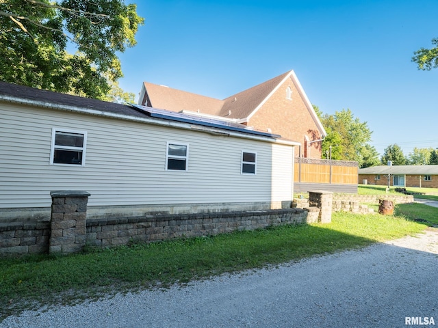 view of side of property featuring roof mounted solar panels