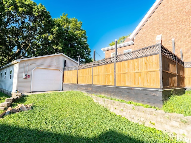 view of yard featuring fence, an outdoor structure, and a garage