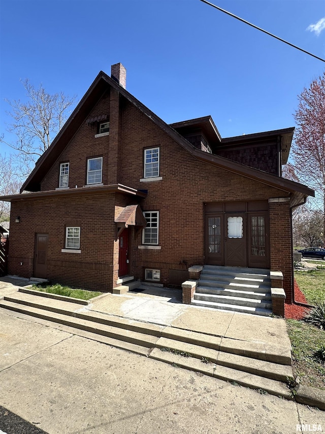 949 NE Glen Oak Ave, Peoria, IL 61603 - view of front of home featuring entry steps, a chimney, and brick siding
