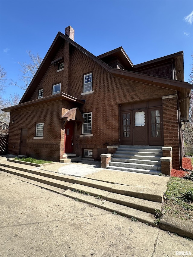 949 NE Glen Oak Ave, Peoria, IL 61603 - view of front of home with entry steps, a chimney, and brick siding