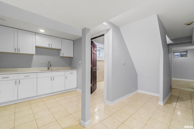 949 NE Glen Oak Ave, Peoria, IL 61603 - kitchen with white cabinets, light tile patterned floors, light countertops, and a sink