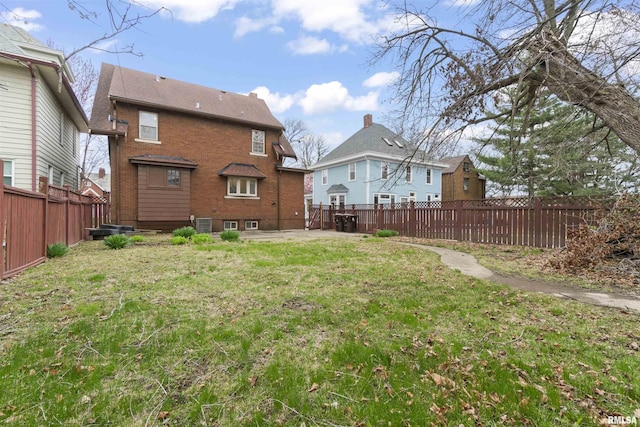 949 NE Glen Oak Ave, Peoria, IL 61603 - back of house featuring a fenced backyard, a patio area, and a lawn