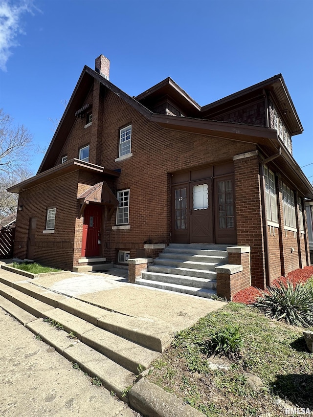 949 NE Glen Oak Ave, Peoria, IL 61603 - view of front of home featuring entry steps, brick siding, and a chimney