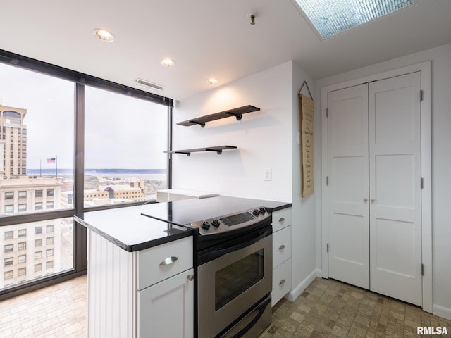 kitchen with visible vents, recessed lighting, expansive windows, open shelves, and electric range