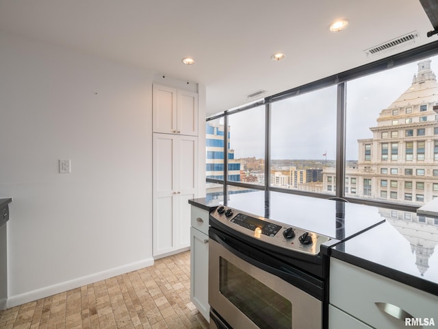 kitchen featuring white cabinetry, recessed lighting, baseboards, stainless steel electric stove, and visible vents
