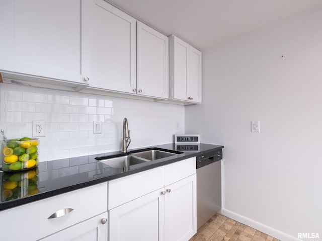 kitchen featuring white cabinetry, tasteful backsplash, stainless steel dishwasher, a sink, and dark countertops