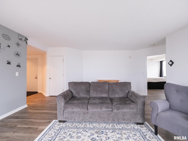 living area with baseboards and wood finished floors