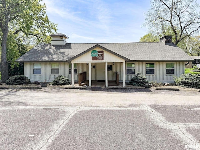 10 Locust Grove Ct, Groveland, IL 61535 - view of front of home with a shingled roof, a chimney, and a porch