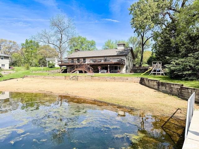 10 Locust Grove Ct, Groveland, IL 61535 - back of house with a deck with water view, stairs, a chimney, and a playground