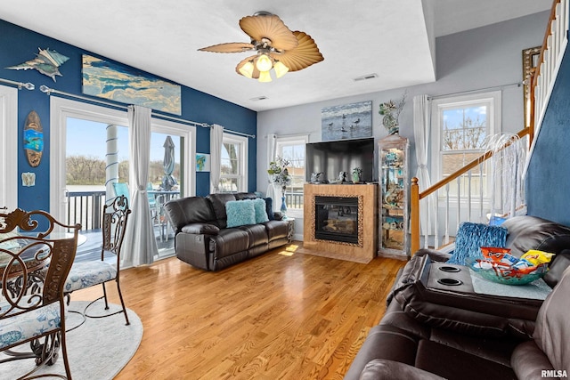 1800 Mitchell St, Pekin, IL 61554 - living room featuring stairway, a ceiling fan, a fireplace with flush hearth, visible vents, and light wood-style floors