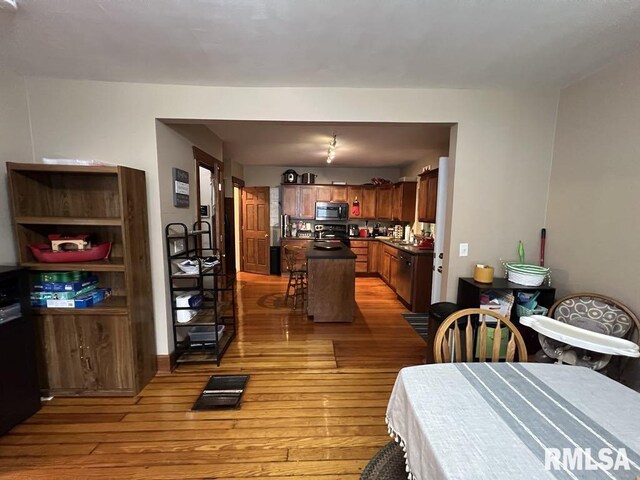 822 S Mcarthur St, Macomb, IL 61455 - kitchen featuring black appliances, dark countertops, light wood-style flooring, and rail lighting