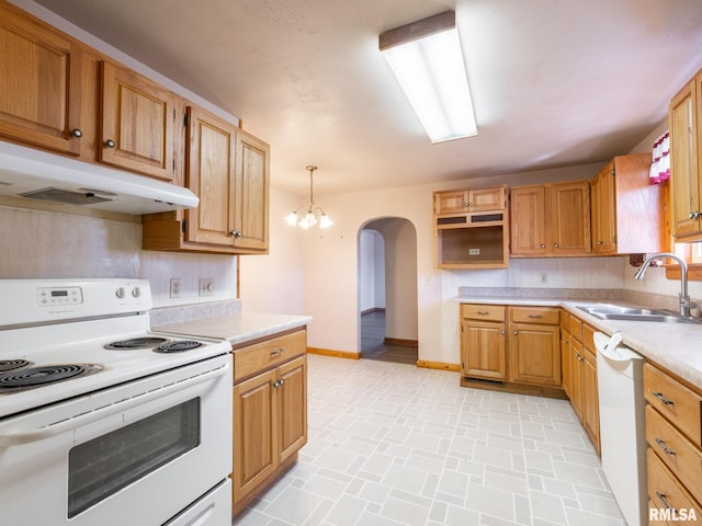 102 S Van Buren St, Lewistown, IL 61542 - kitchen with light countertops, white appliances, under cabinet range hood, a sink, and arched walkways