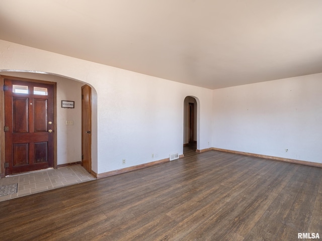 102 S Van Buren St, Lewistown, IL 61542 - interior space with arched walkways, visible vents, wood finished floors, and baseboards