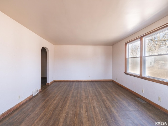 102 S Van Buren St, Lewistown, IL 61542 - spare room with arched walkways, baseboards, visible vents, and wood finished floors
