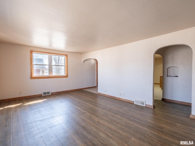 102 S Van Buren St, Lewistown, IL 61542 - unfurnished room with wood finished floors, arched walkways, and visible vents