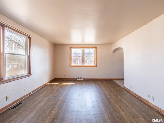 102 S Van Buren St, Lewistown, IL 61542 - spare room featuring arched walkways, baseboards, visible vents, and wood finished floors
