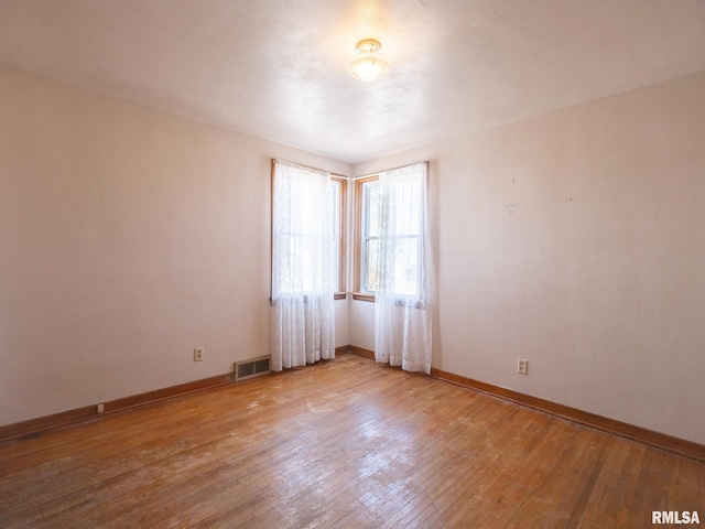 102 S Van Buren St, Lewistown, IL 61542 - empty room featuring baseboards, visible vents, and wood finished floors
