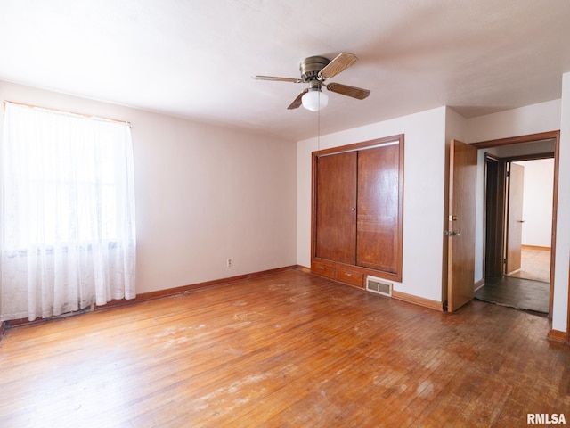 102 S Van Buren St, Lewistown, IL 61542 - unfurnished bedroom featuring wood-type flooring, a ceiling fan, baseboards, and visible vents