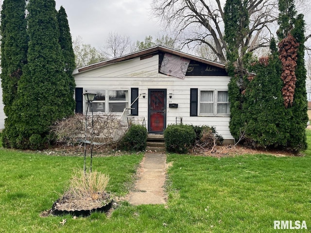 bungalow-style house featuring a front lawn