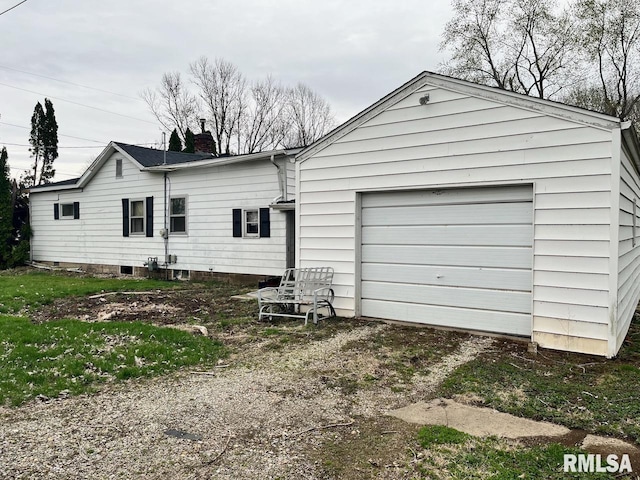 rear view of house with a garage, driveway, and a chimney