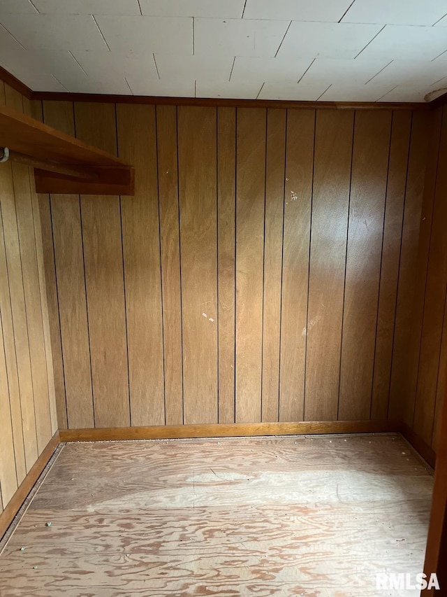 empty room with light wood finished floors and wooden walls