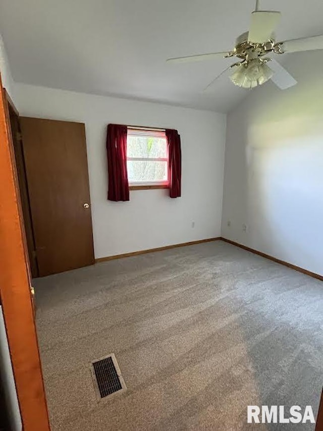 unfurnished room with ceiling fan, carpet flooring, baseboards, and lofted ceiling