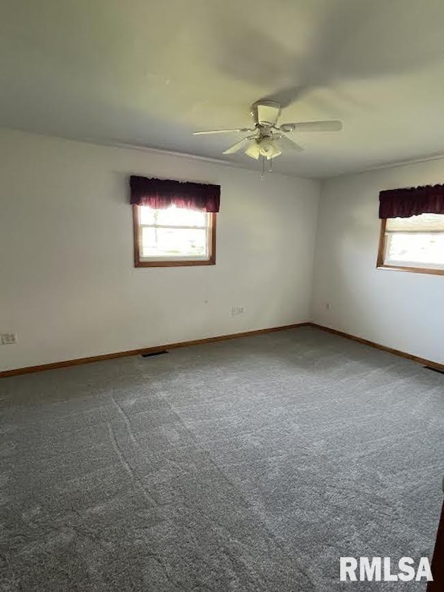 unfurnished room with ceiling fan, baseboards, and carpet