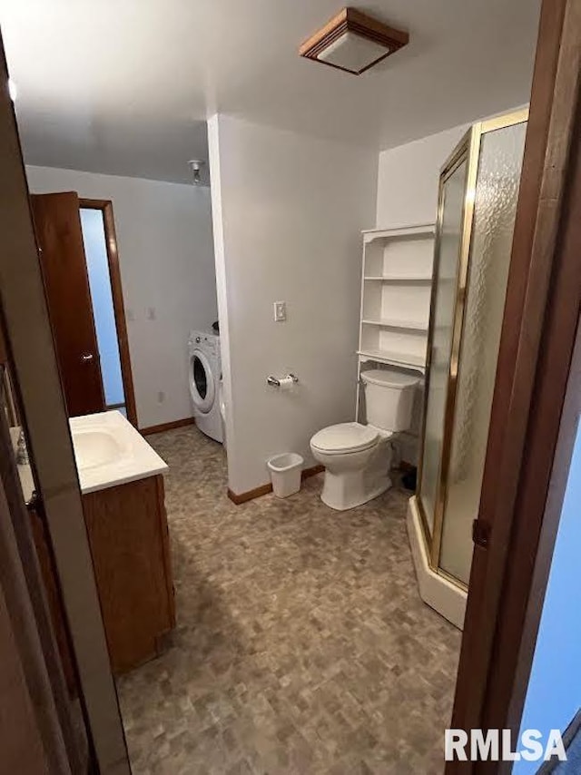 bathroom with washer / dryer, tile patterned floors, a stall shower, vanity, and toilet