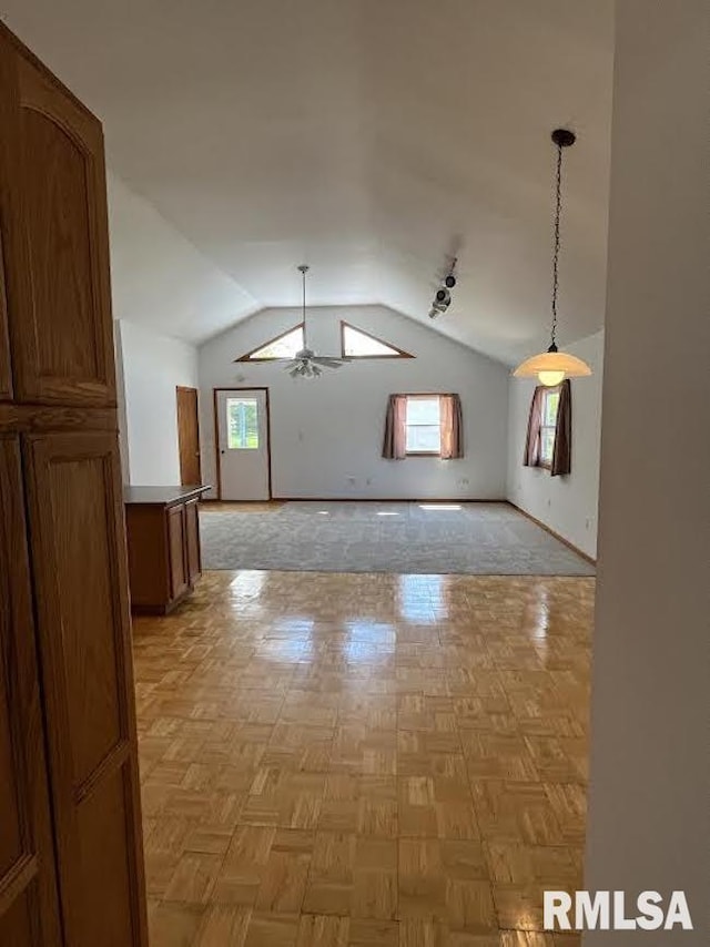 unfurnished room featuring lofted ceiling, baseboards, and a ceiling fan
