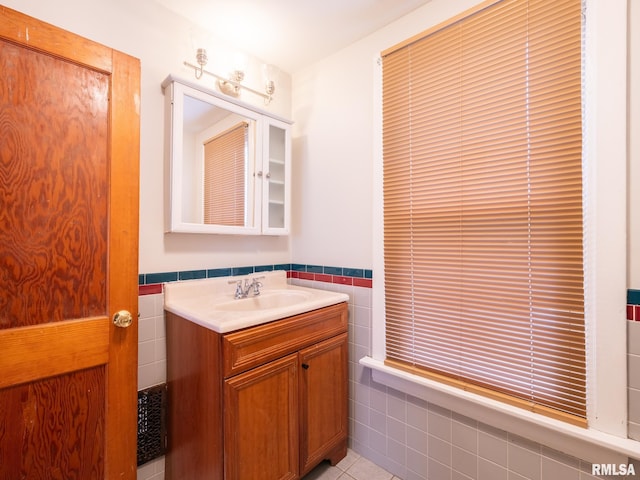 943 NE Glen Oak Ave, Peoria, IL 61603 - bathroom featuring tile patterned flooring, vanity, tile walls, and wainscoting