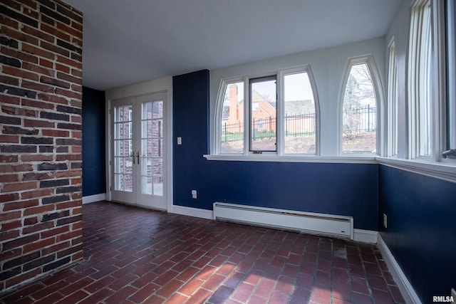 unfurnished sunroom featuring french doors and a baseboard heating unit