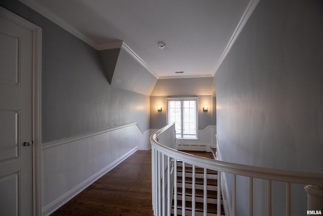 corridor with a baseboard heating unit, ornamental molding, an upstairs landing, wainscoting, and wood finished floors