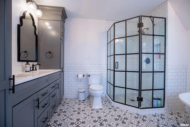 full bath featuring toilet, tile walls, a wainscoted wall, a shower stall, and tile patterned floors