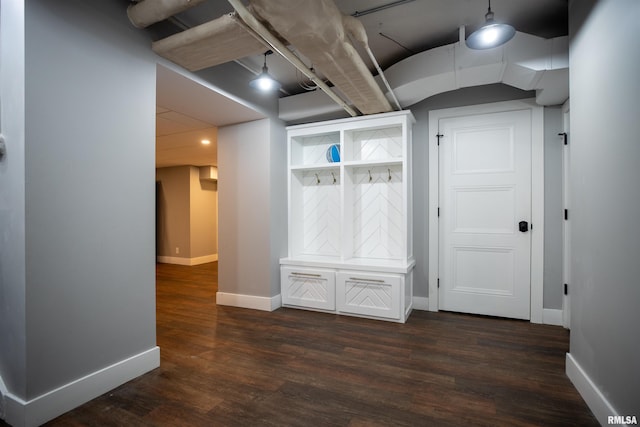 interior space featuring baseboards and dark wood finished floors