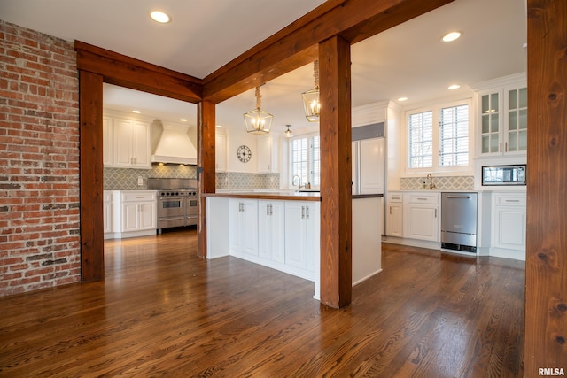 kitchen with premium range hood, appliances with stainless steel finishes, dark wood-style floors, and white cabinets