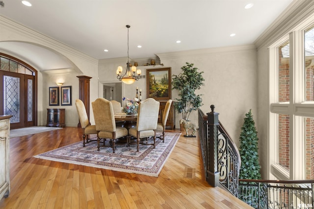 1801 Kern Rd, Washington, IL 61571 - dining area with a chandelier, wood-type flooring, arched walkways, decorative columns, and ornamental molding