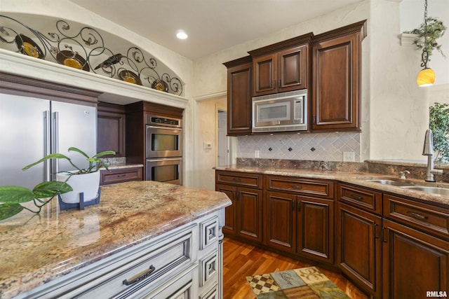 1801 Kern Rd, Washington, IL 61571 - kitchen featuring stainless steel appliances, a sink, dark wood finished floors, light stone counters, and tasteful backsplash