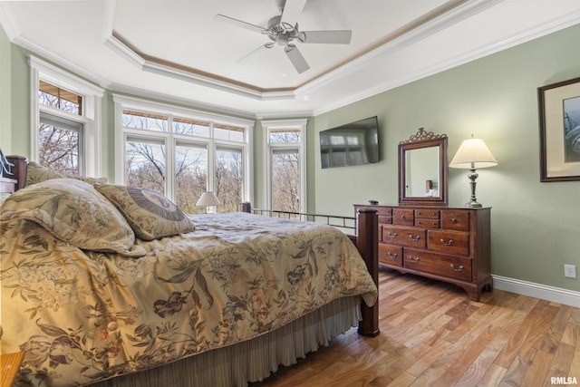 1801 Kern Rd, Washington, IL 61571 - bedroom featuring light wood-style floors, a tray ceiling, crown molding, baseboards, and a ceiling fan