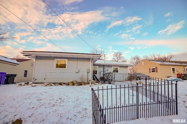 snow covered rear of property with fence