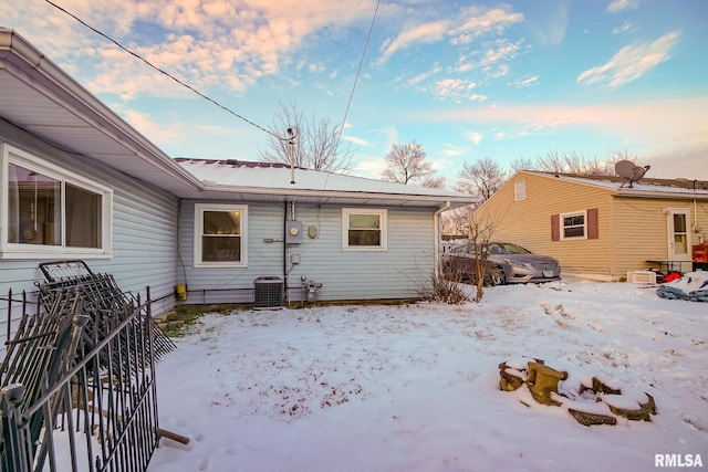 snow covered house with central AC unit