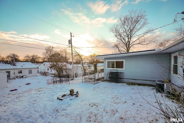 yard layered in snow with central air condition unit and fence