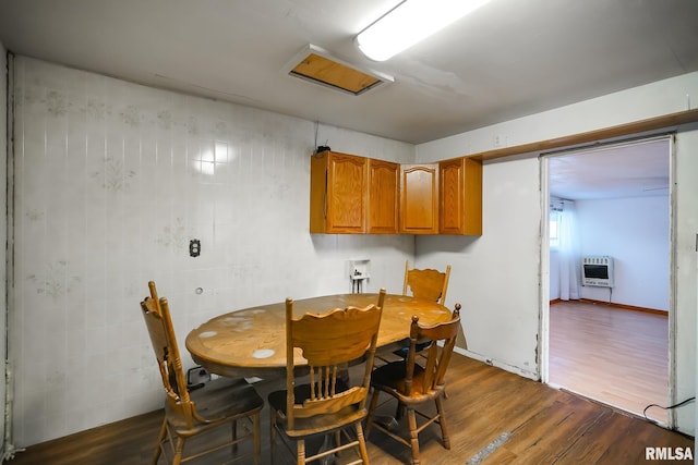 dining room with heating unit and dark wood-style floors
