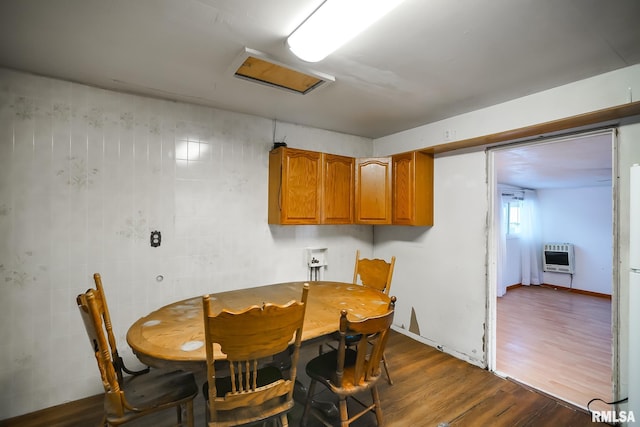 dining space featuring heating unit and dark wood-style floors
